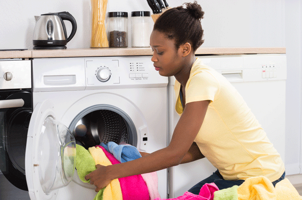 Woman loads washing machine.